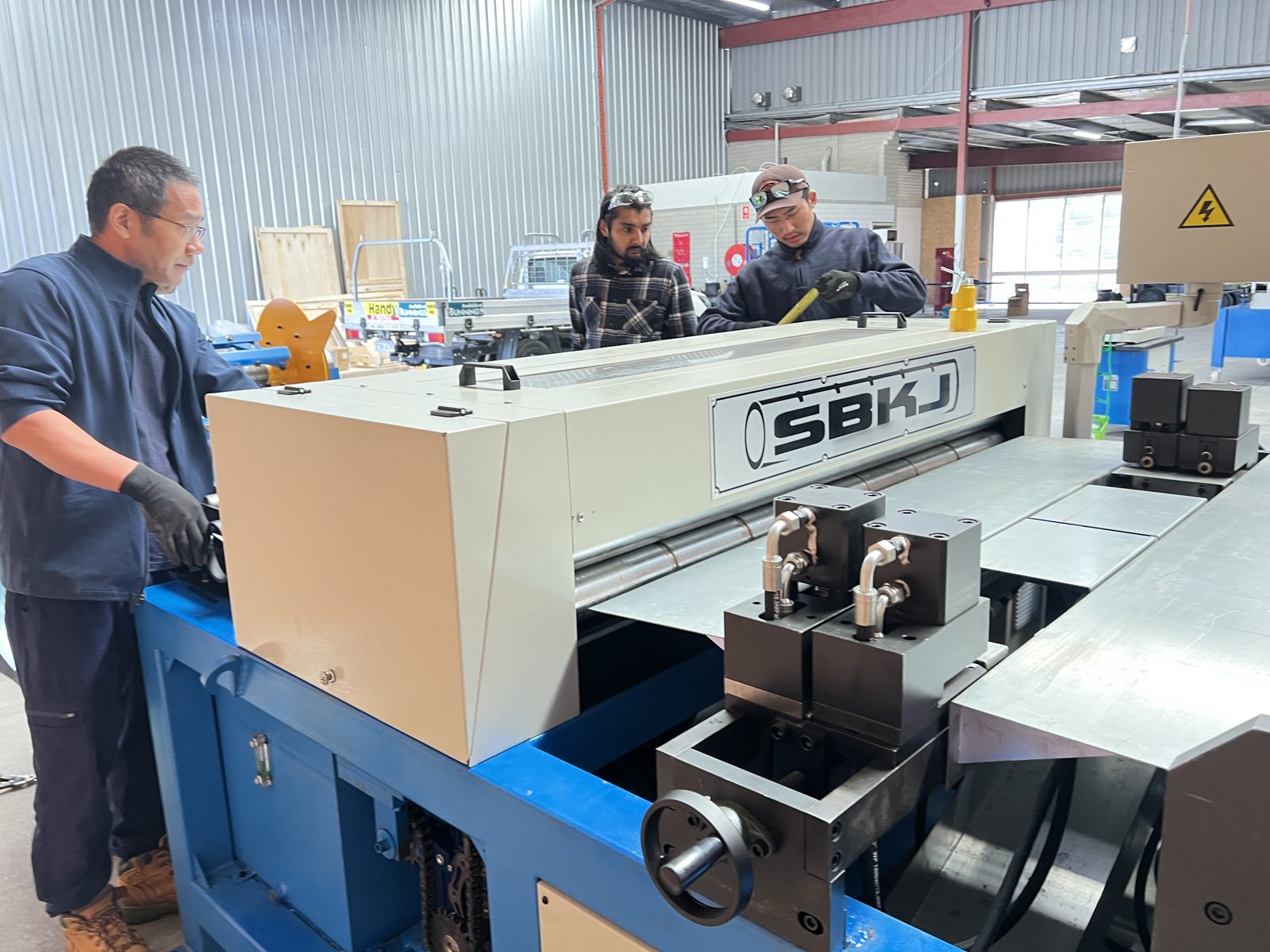 Airtemp operators measuring a panel on the Taokron lockformer