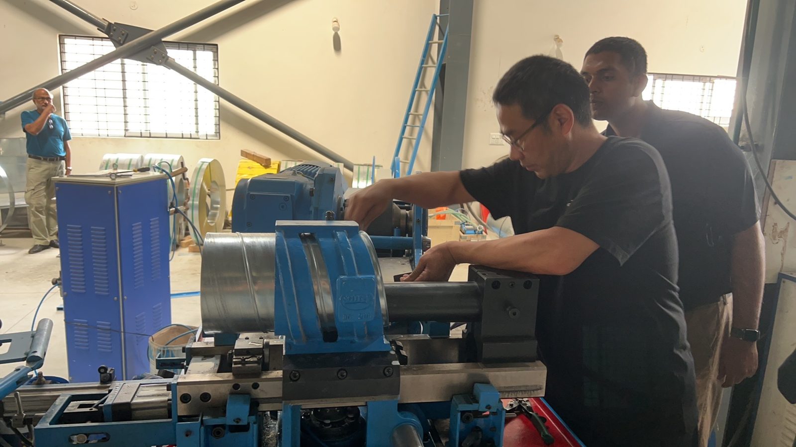 A Taokron engineer setting up a spiral duct flanging machine on site in India